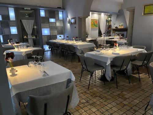 Villa Nasti Hotel Ristorante في Canzo: غرفة مع طاولات وكراسي مع مفارش بيضاء
