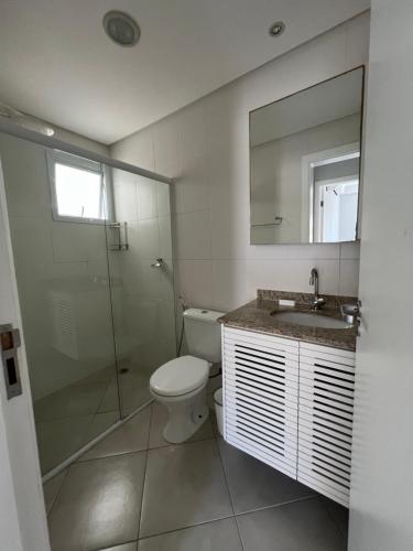 a bathroom with a toilet and a shower and a sink at Apartamento Praia Grande 405 in Ubatuba