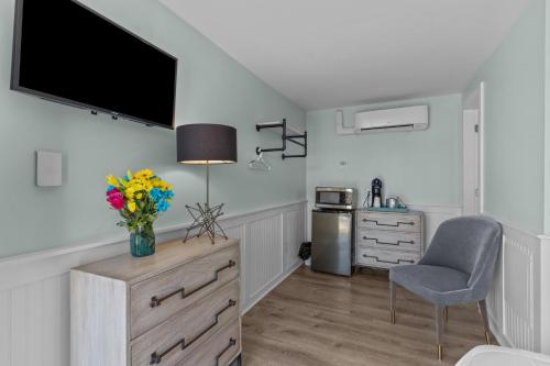 a kitchen with a dresser with a tv on the wall at Loggerhead Inn and Suites in Surf City