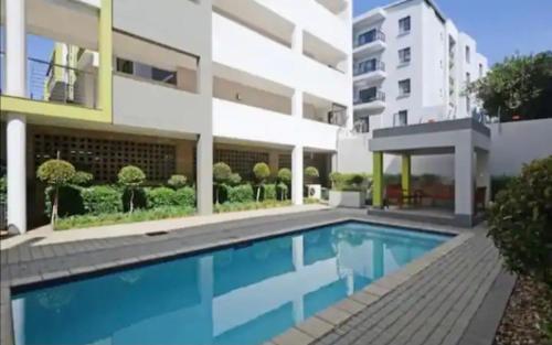 una piscina frente a un edificio en Apartment in Sandton, Rivonia en Johannesburgo