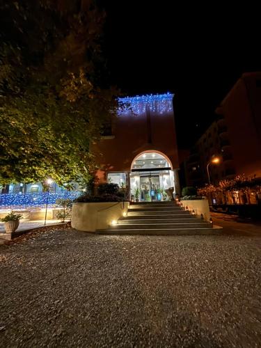 een gebouw met trappen voor een gebouw met blauwe lichten bij Villa Nasti Hotel Ristorante in Canzo