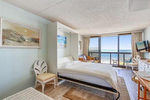 a bedroom with a bed and a view of the ocean at Golden Sands 605 in Ocean City