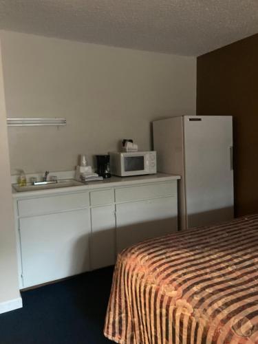 een kamer met een keuken met een magnetron en een koelkast bij Travelodge by Wyndham Canyonville in Canyonville