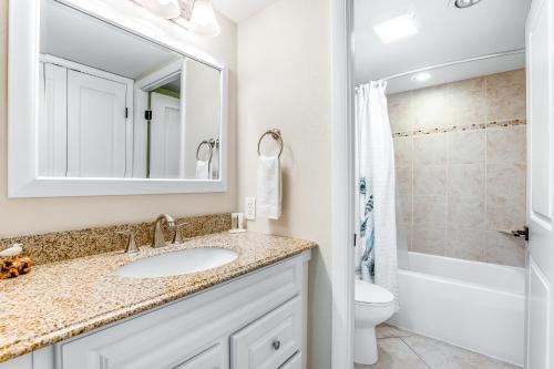 a bathroom with a sink and a toilet and a mirror at Golden Sands 607 in Ocean City