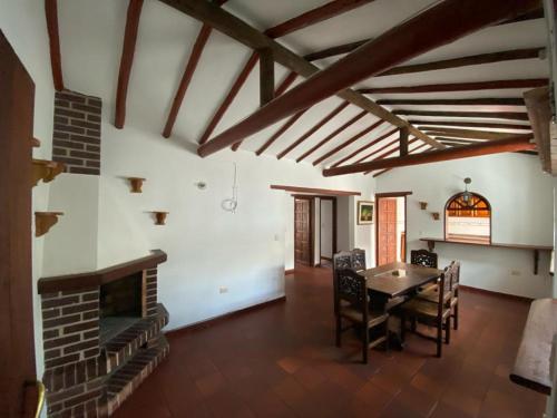 een woonkamer met een tafel en een open haard bij Muisca Hotel Villa de Leyva in Villa de Leyva