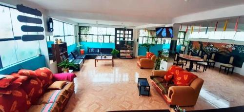una gran sala de estar con sofás y un comedor. en Casa Samay Mountain View, en Ollantaytambo