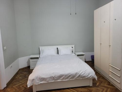 a bedroom with a white bed with two white cabinets at Condor in Arad
