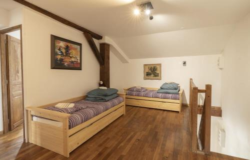 2 camas en una habitación con suelo de madera en Retrouvailles Vosges comtoises msp Raphi et Gabi SPA, en Mailleroncourt-Saint-Pancras