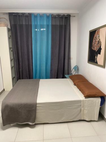 a bed in a room with a blue window at Los Gigantes in front of Sea in Acantilado de los Gigantes