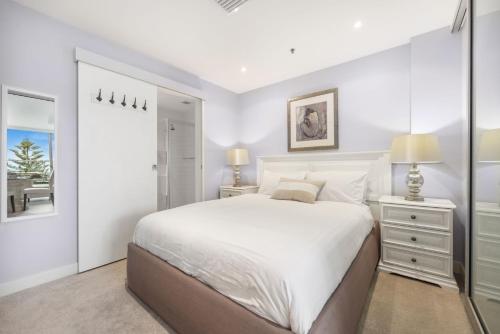 a white bedroom with a large bed and a window at Belle Escapes - Bay View Lookout With Sea Views in Glenelg