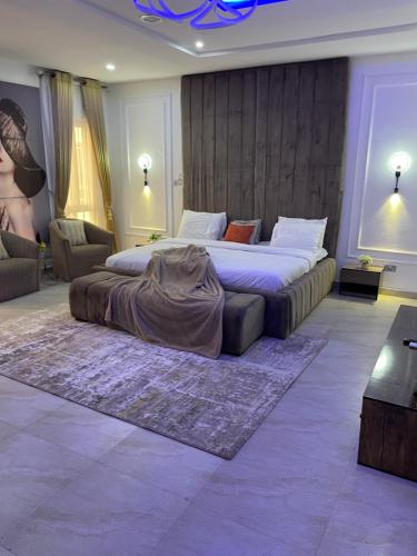 a bedroom with a large bed and a couch at The King's Landing Apartments in Maiyegun