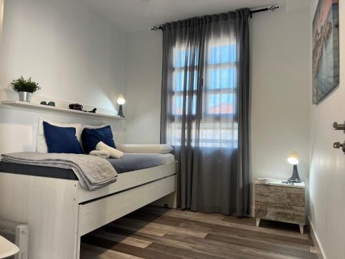 Un dormitorio con una cama con almohadas azules y una ventana en AGUA DULCE , Apartamento Rural, en Herrera del Duque