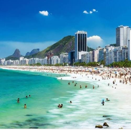 a group of people in the water at a beach at Botafogo Guesthouse in Rio de Janeiro