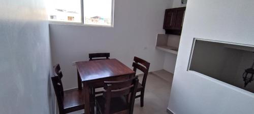 巴克里索莫雷诺港Mantarraya的餐厅里有一张桌子、几把椅子和一台电视。
