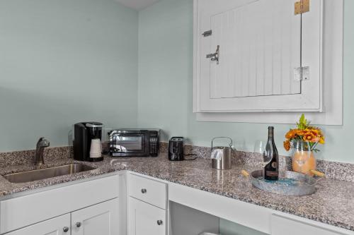 a kitchen counter with a sink and a bottle of wine at Loggerhead Inn and Suites in Surf City