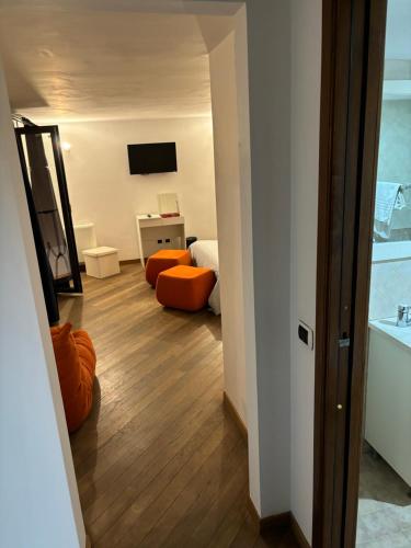 ローマにあるBoutique rooms trastevereのベッドルーム1室(オレンジの椅子、鏡付)