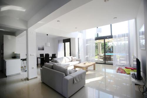 ein Wohnzimmer mit einem Sofa und einem Tisch in der Unterkunft Sunny Sani Luxury Villas in Sani Beach