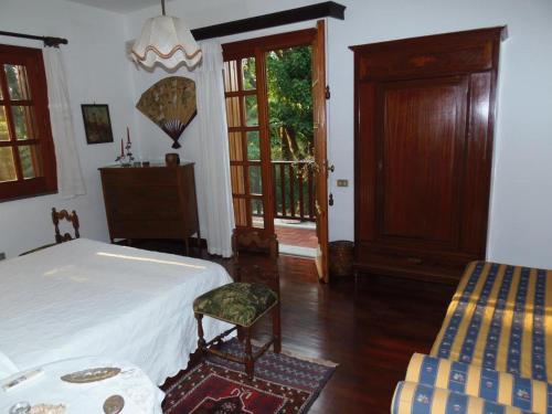 een slaapkamer met een bed, een stoel en een deur bij La Semenza in Torre Archirafi