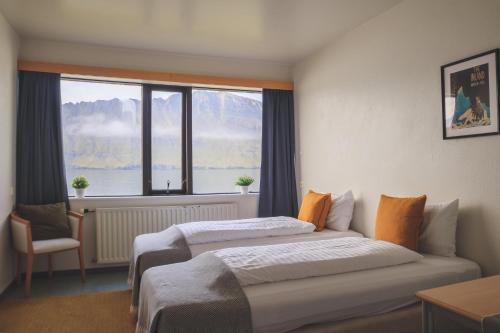 a hotel room with two beds and a window at The Cliff Hotel in Neskaupstaður