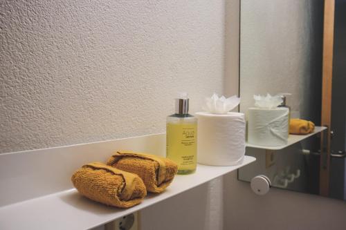 a bathroom with a shelf with towels and a mirror at The Cliff Hotel in Neskaupstaður