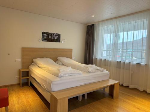 a bed in a room with a large window at Hotel Eskifjörður in Eskifjörður