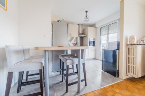une cuisine avec une table et des tabourets dans une pièce dans l'établissement Le Refuge de l'Écrivain - 2 Chambres, à Brive-la-Gaillarde