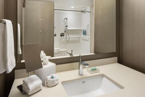 a bathroom with a sink and a large mirror at Courtyard by Marriott Minneapolis West in Saint Louis Park