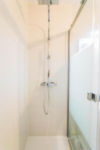 une douche avec une porte vitrée dans une salle de bain dans l'établissement Le Refuge de l'Écrivain - 2 Chambres, à Brive-la-Gaillarde