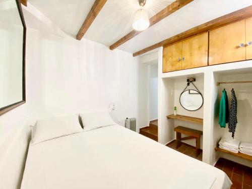 una camera con letto bianco e armadi in legno di La Cueva Milos ad Adámas
