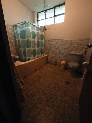 ein Bad mit einer Dusche und einem WC in der Unterkunft Casa hospedaje cora in Barrio Bellavista