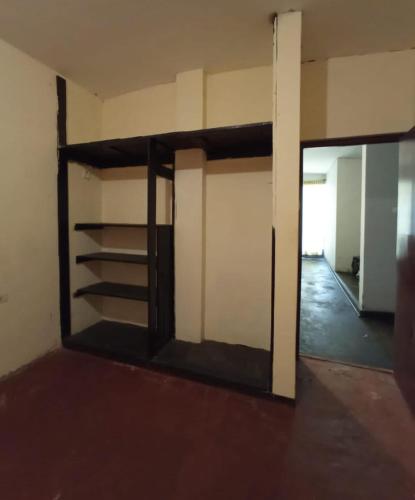 una habitación vacía con una puerta y estanterías en una pared en Casa hospedaje cora, en Barrio Bellavista