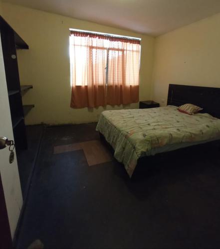 Schlafzimmer mit einem Bett und einem Fenster in der Unterkunft Casa hospedaje cora in Barrio Bellavista