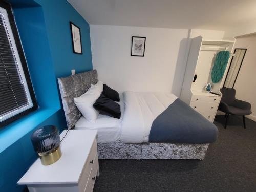 a bedroom with a bed and a blue wall at Premier Studios Nottingham - Tring Vale in Nottingham