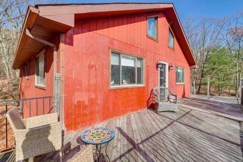 a red house with a large wooden deck at Cozy Pennsylvania Home with Pool Table and Pool Access in Effort