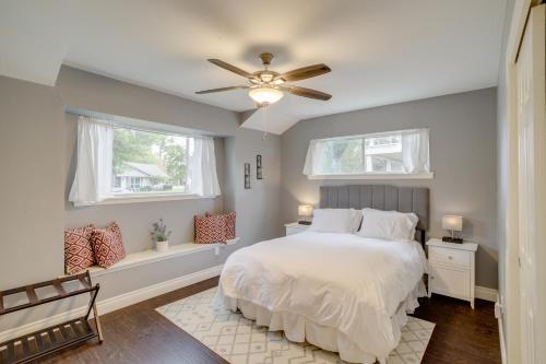 a bedroom with a white bed and two windows at Updated Houston Home with Backyard and Ping Pong! in Houston