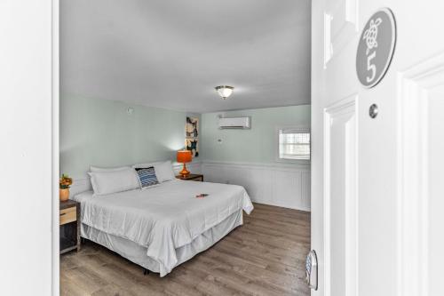 a bedroom with a bed with a white bedspread at Loggerhead Inn and Suites in Surf City