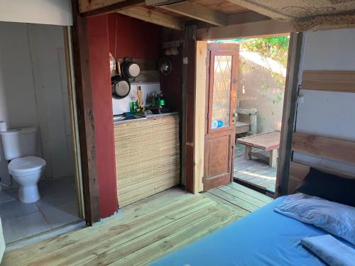 um quarto com uma casa de banho com um WC e uma porta em Solar Valizas em Barra de Valizas