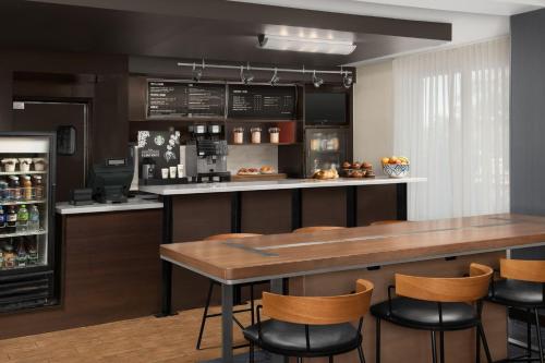 a kitchen with a bar with a table and chairs at Courtyard by Marriott Dothan in Dothan