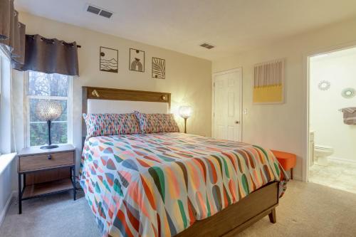 a bedroom with a bed with a colorful comforter and a window at Chic Lexington Home with Deck about 5 Mi to Downtown! in Lexington
