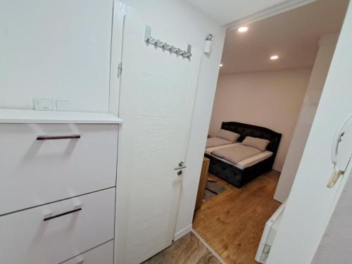 een keuken met een kast en een bed in een kamer bij Apartman EM in Sarajevo
