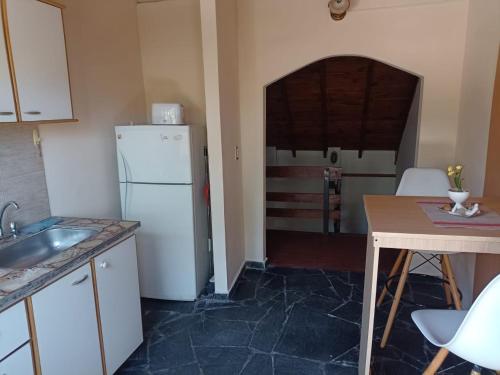 a kitchen with a white refrigerator and a table at CHE LOLITA HOUSE 3 in El Palomar