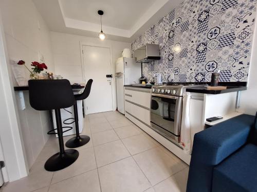 a kitchen with a stove and a blue and white wallpaper at Laguna Linda Vista in São Paulo