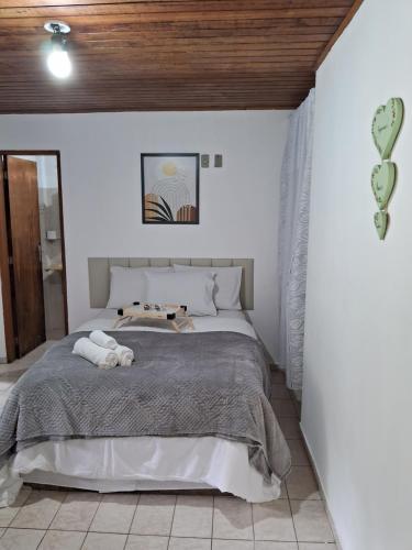 um quarto com uma cama numa parede branca em Chalé do riacho 2 em Penedo
