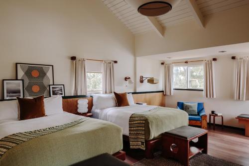 a bedroom with two beds and a chair and windows at Lodge At Marconi in Marshall