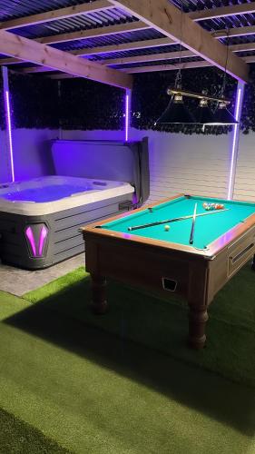 a room with a pool table and a tub at The Chroma Cottage in Cock Hill