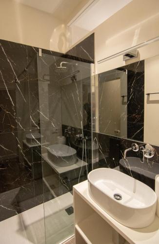 a bathroom with a sink and a glass shower at Palazzo Lachman rooms in Trento