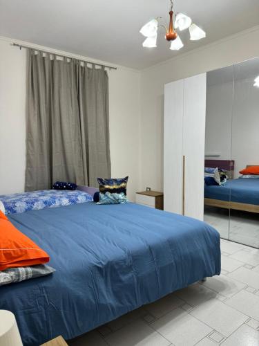 una camera da letto con un letto blu e uno specchio di Home 5.1 a Napoli