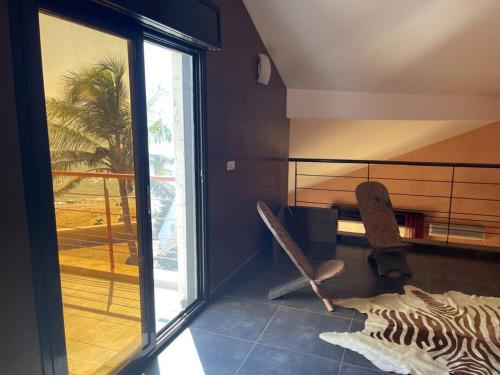 Habitación con ventana y silla en La maison du bonheur en Ouoran