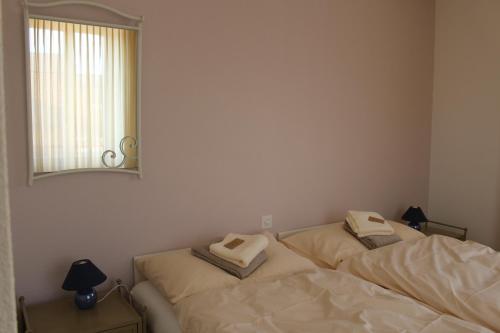 two beds in a room with a mirror on the wall at Hôtel de la Gare in Yvonand