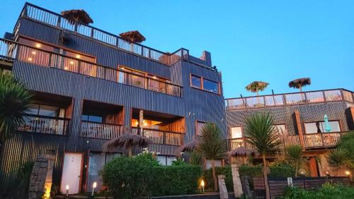 a building with balconies and trees in front of it at Moana Pichilemu Lodge in Pichilemu